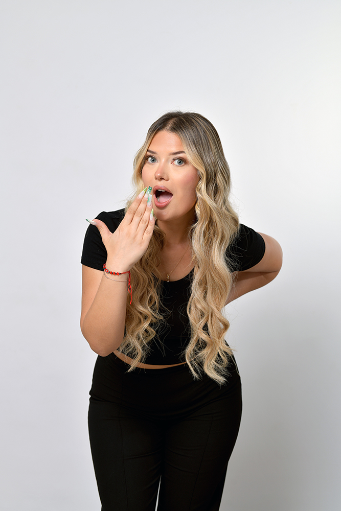 Modèle femme blonde aux yeux bleus avec haut noir. Séance photo en studio pour salon de coiffure spécialisé dans les extensions de cheveux. Photo prise par Alexandre Escudero Photographe Grenoble.